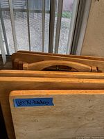 Close-up of stacked wooden TV tray tables with label indicating six TV tables.
