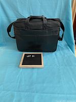 Front view of the black Dell computer bag with dual handles and zippered front pocket.