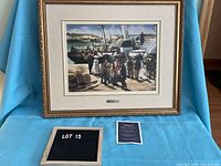 Framed replica oil painting depicting people near boats at a harbor with a visible gold-colored frame and white mat, displayed against a blue backdrop with accompanying certificate and lot number plaque.