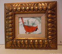 Photo shows enamel on copper artwork of a cardinal in a gold-toned ornate frame with raised bumps, approximately 10.5 x 9.5 inches including frame.
