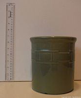 Side view of sage green Longaberger pottery crock with a ruler showing height approximately 6 inches.