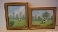 Two framed enamel on copper paintings showing children playing outdoors with grassy and blurred background.