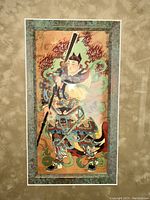 Framed silk reproduction showing Yan-Tien, one of the Wardens of Heaven, in traditional armor with sword and flames, green marbleized border.