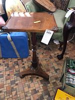 Photo of Edwardian mahogany occasional table showing rectangular top with carved scroll details in corners, central pedestal and tripod base.