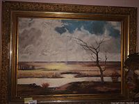 Full front view of framed oil painting showing landscape scene and ornate gilt frame