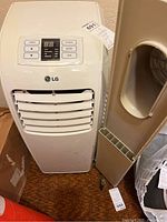 Front view of LG portable air conditioner showing control buttons and vent louvers.