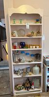 Photo of the full cabinet with all contents visible including glassware, ceramics and decor items.