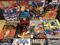 Photo showing front covers of 12 comic books including Marvel and DC titles as detailed, arranged in two rows on a flat surface.