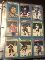 Binder page with 9 hockey cards including notable players Doug Jarvis, Guy Lapointe, Bobby Smith rookie, Marty Howe, Rick Martin, Terry O'Reilly and team checklists.