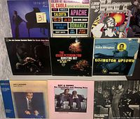 Photo of 9 jazz vinyl LP records including Oscar Peterson Trio, Duke Ellington Uptown, and John Holt 1000 Volts album.