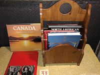 Books arranged inside the wooden magazine/book stand showing front covers of some titles.