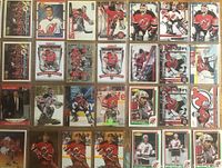 Front view of multiple New Jersey Devils hockey cards in sleeves showing Martin Brodeur in various poses plus other Devils players.