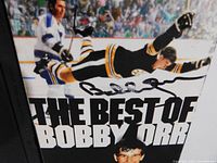 Close-up of the VHS tape front cover showing Bobby Orr in action and autograph on the cover.