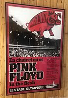 Full view of framed poster showing red flying pig graphic above crowd photo and text 'Pink Floyd In the Flesh' and venue info.
