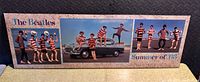Full view of the triptych poster on board showing The Beatles with beach and car scene and text 'The Beatles Summer of '63'