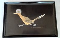 Top-down view of black rectangular tray featuring an inlaid roadrunner design covering the center.