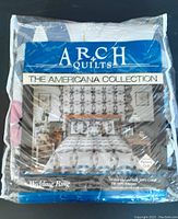Image of quilt packaging showing brand Arch Quilts, The Americana Collection, and Wedding Ring pattern name with bedding set on a bed.