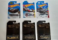 Six Hot Wheels cars in original packaging, showing a variety of designs including a Batmobile and 50th Anniversary editions.