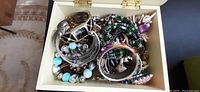 Top down view of jewelry collection showing multiple bracelets and bangles in jewelry box