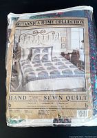 Original packaging of the Britannica Home Collection hand sewn patchwork quilt for king size bed, showing printed label with product details and a picture of the quilt on a bed.