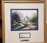 Framed print of a garden scene with a white gazebo, surrounded by colorful flowers and trees, bordered by blue and cream matte, includes a biblical quote and engraved plaque.