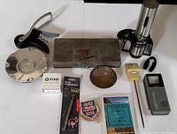 Overview of the lot with all items visible on a table, showing tools, household, and electronic devices.
