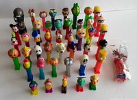 Front and overall view of 41 vintage Pez dispensers showing large variety of character heads with colorful bases.