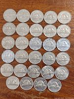 Photo of the reverse sides of 5-cent Canadian coins featuring the common beaver design. Coins are arranged in rows and show dates from 1922 to 1968.