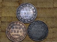 Obverse of three Canadian one cent coins dated 1876, 1888, and 1893 with denomination and wreath design.