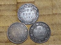 Reverse sides of three Canadian one cent coins dated 1896, 1899, and 1902 showing 'ONE CENT' and maple leaf wreath.