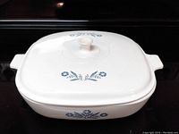 Square white casserole dish with lid showing blue cornflower floral pattern on sides and top of lid