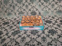 Top down view of 12 clear glass canning jars arranged in packaging box with 'Kirkland Solid Light Tuna' branding visible on box sides.