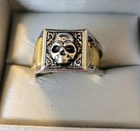 Front view of the ring showing the detailed skull design and side gold-tone accents.