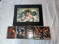 Photo showing entire lot with holographic print, 4 DVDs, and 1 VHS tape displayed on white fabric background.