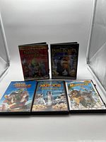 Front view of 5 DVD cases upright showing their cover art and titles.