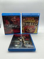 Front view of three Blu Ray horror movies Mary, Trick or Treat, and Survival of the Dead with distinct cover art and blue cases.