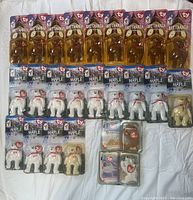 Photo showing 24 new in package Ty Beanie Babies including 12 Britannia bears, 10 Maple bears, and 2 additional bears on card.