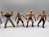 Photo showing all 4 WCW wrestling action figures side by side, posed with fists raised or flexing