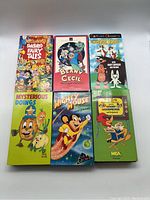 Front view of 6 classic cartoon VHS tapes showing colorful covers with titles and characters for Fractured Fairy Tales, Beany and Cecil, Crusader Rabbit, Mysterious Doings, Mighty Mouse, Woody Woodpecker.