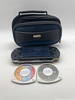 Photo showing PSP console, carrying case, and two UMD game discs in front