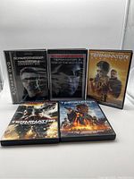 Front view of five Terminator DVD cases showing Arnold Schwarzenegger as the Terminator character, including titles Judgment Day, Rise of the Machines, Dark Fate, Salvation, and Genisys