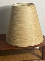 Front view of beige conical lampshade showing overall shape and texture