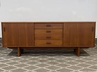 Front view of teak credenza with drawers and sliding doors closed