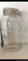 Front view of large clear glass preserving jar showing embossed beaver and word 'BEAVER' below it, with metal screw-on lid.