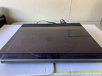 Overhead view of closed turntable showing smoke-tinted dust cover and overall chassis