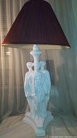 Full view of the lamp showing three ladies sculpture base and dark lamp shade