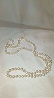 Full view of 16 inch knotted baroque pearl necklace laid out showing length and shape variety of pearls.