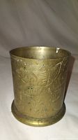 Front view showing etched floral and leaf designs on cylindrical brass holder