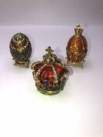 Three jeweled magnetic trinket holders displayed: two egg-shaped holders and one crown-shaped holder on a white background.