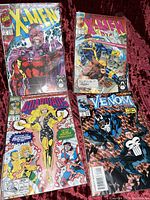 Photo shows all four comic books, front covers visible including X-Men, Venom, and Guardians of the Galaxy